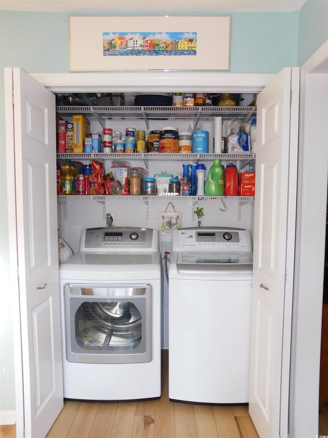 laundry room featuring light wood-style floors, laundry area, and washer and clothes dryer