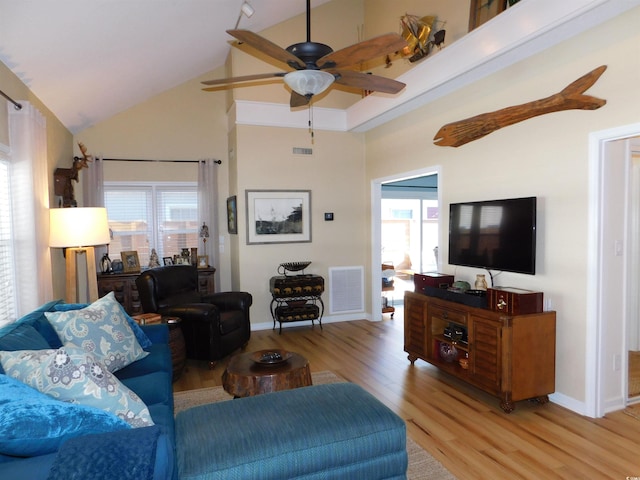 living room with high vaulted ceiling, light wood-style floors, visible vents, and a healthy amount of sunlight