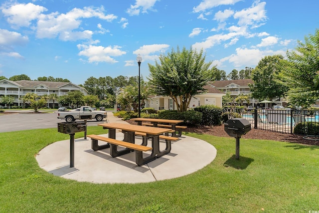 surrounding community with a residential view, fence, and a lawn