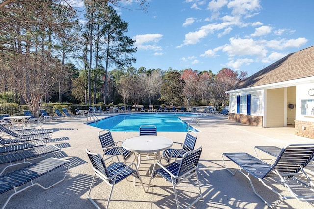 pool with a patio area and fence