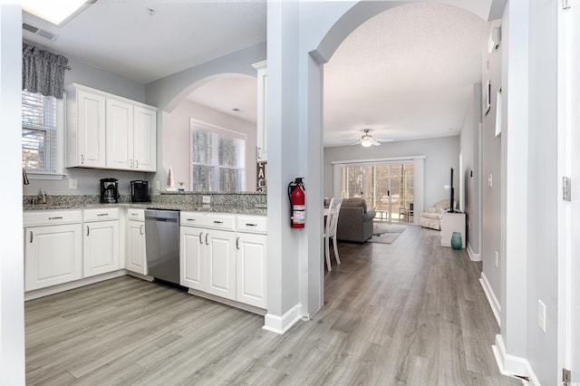 kitchen featuring light stone counters, light wood-style flooring, open floor plan, white cabinetry, and dishwasher