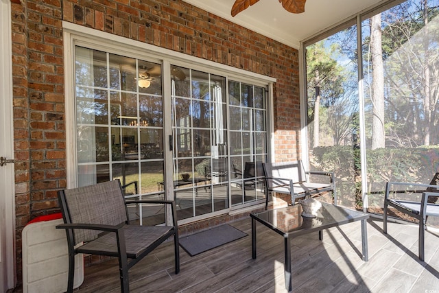 unfurnished sunroom featuring ceiling fan