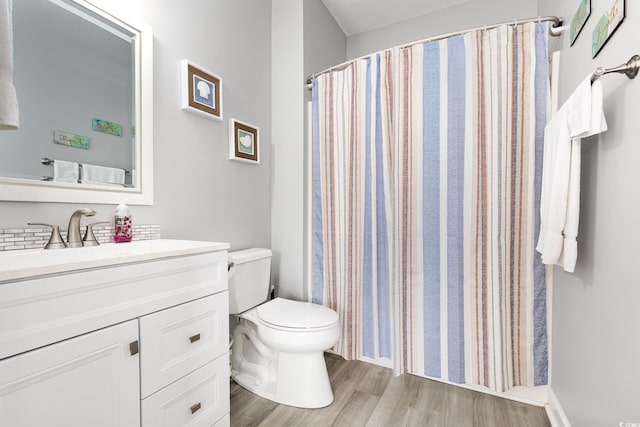 bathroom with vanity, wood finished floors, toilet, and a shower with curtain