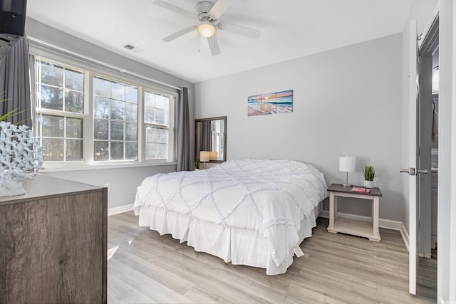 bedroom featuring visible vents, ceiling fan, light wood-style flooring, and baseboards