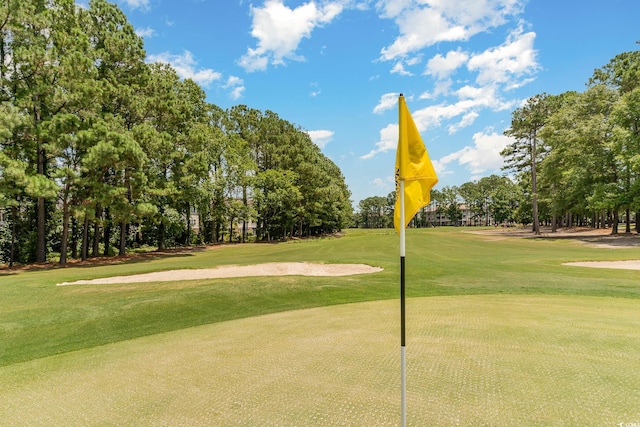 view of home's community featuring golf course view and a lawn