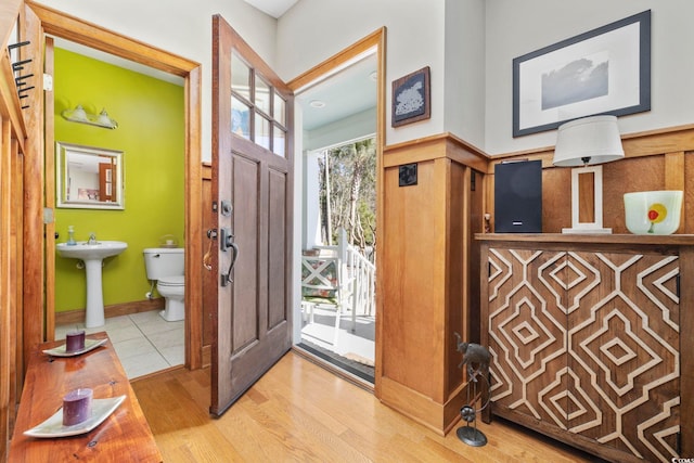 foyer entrance featuring a wainscoted wall and wood finished floors