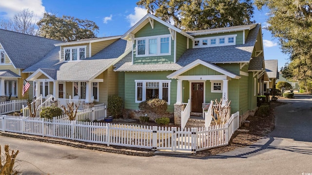 view of front of home with a shingled roof and a fenced front yard