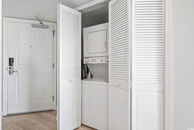 washroom with laundry area, light wood-style floors, and stacked washer / drying machine