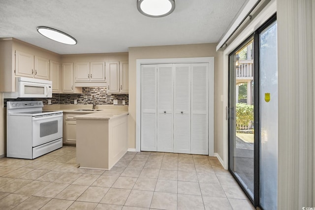 kitchen with white appliances, light countertops, a sink, and light tile patterned floors