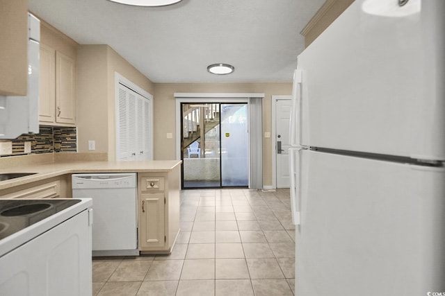 kitchen featuring white appliances, light tile patterned floors, decorative backsplash, a peninsula, and a sink