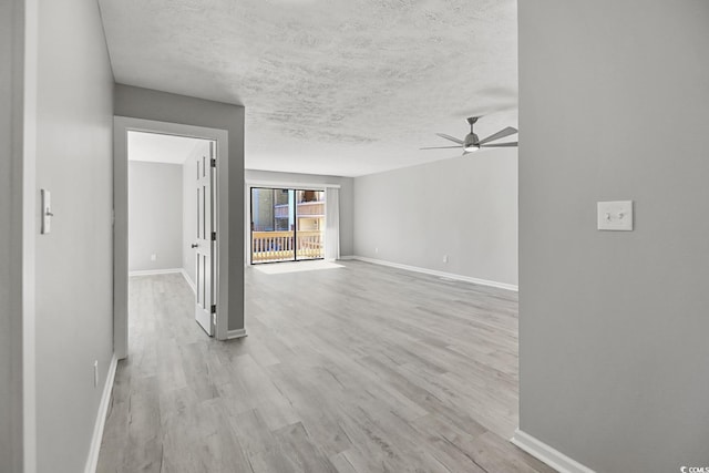 unfurnished living room with baseboards, light wood-style flooring, a ceiling fan, and a textured ceiling