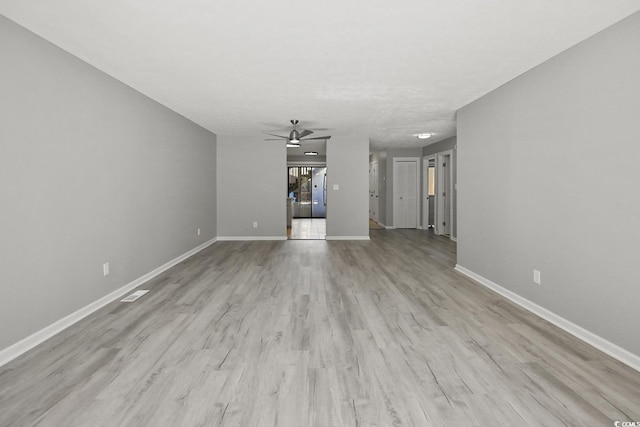 unfurnished living room with ceiling fan, baseboards, and wood finished floors