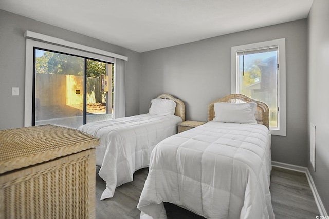 bedroom featuring access to outside, baseboards, and wood finished floors