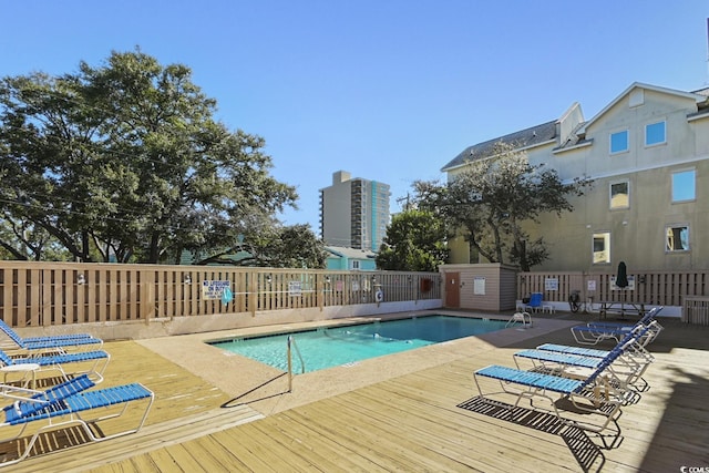 community pool with fence and a deck