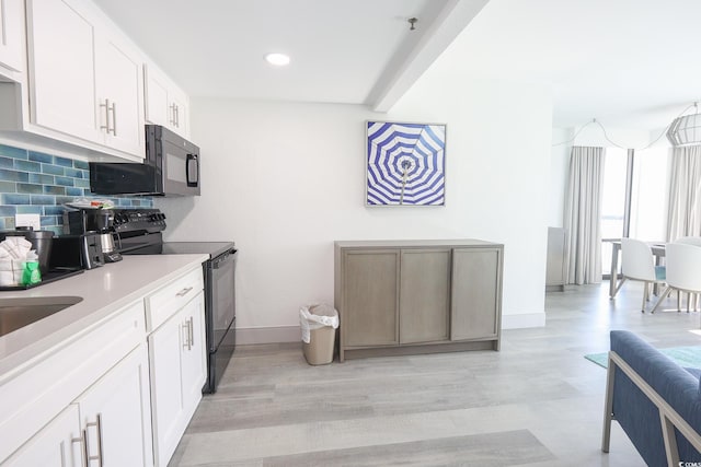 2401 S Ocean Blvd Unit 971, Myrtle Beach, SC 29577 - kitchen with baseboards, decorative backsplash, black appliances, light wood-style floors, and light countertops