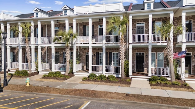 multi unit property featuring brick siding and a porch