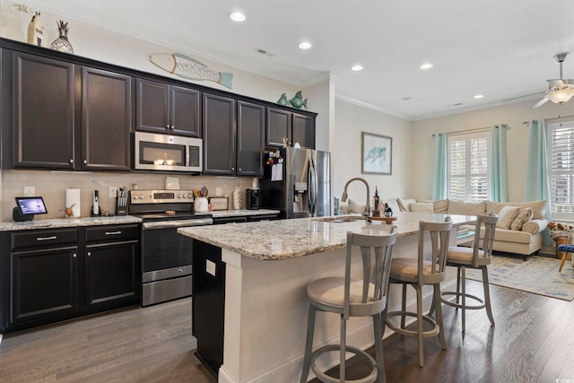 kitchen featuring tasteful backsplash, dark wood finished floors, open floor plan, stainless steel appliances, and a sink