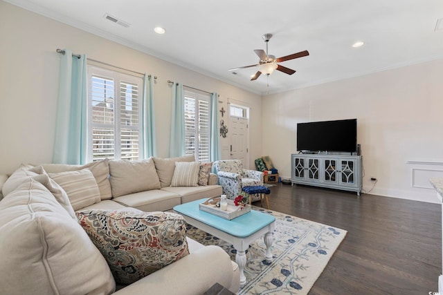 living room with a ceiling fan, visible vents, dark wood-type flooring, and crown molding