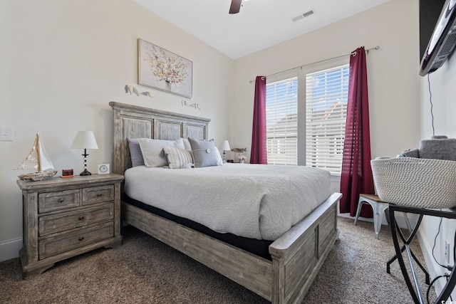 bedroom featuring a ceiling fan, visible vents, and dark carpet