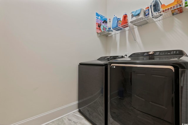 laundry area featuring laundry area, baseboards, and separate washer and dryer