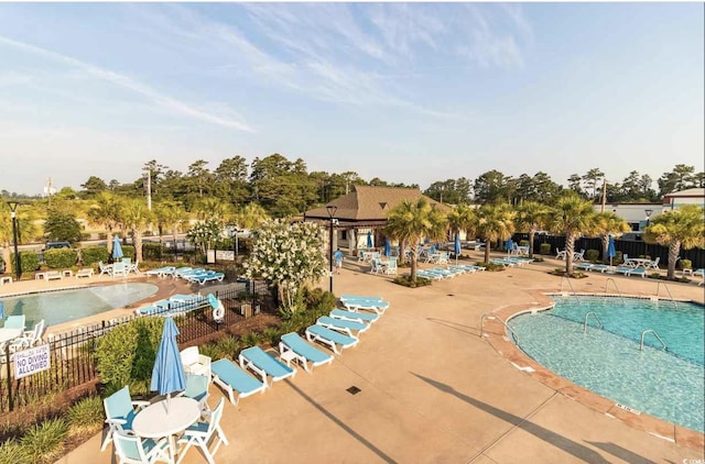 community pool with fence and a patio