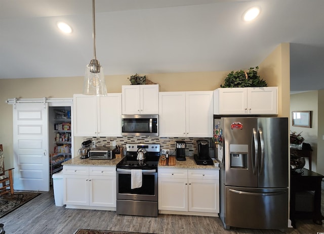 kitchen featuring stainless steel appliances, white cabinets, decorative backsplash, and wood finished floors