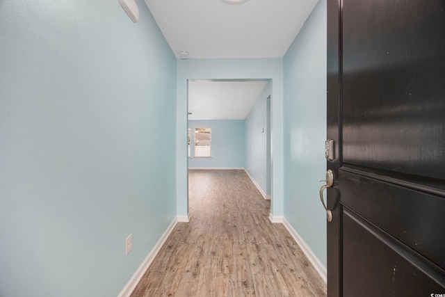 hallway with baseboards and light wood finished floors