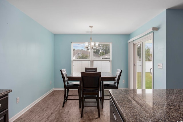 dining room with baseboards, wood finished floors, and an inviting chandelier