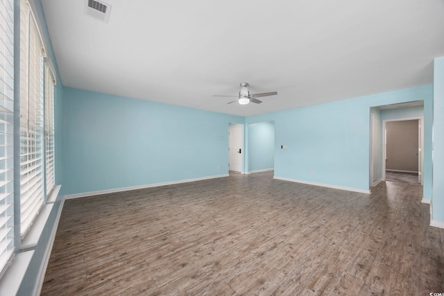 spare room featuring visible vents, a ceiling fan, wood finished floors, and a healthy amount of sunlight