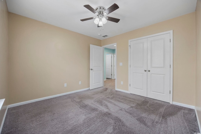 unfurnished bedroom featuring carpet, a closet, visible vents, ceiling fan, and baseboards