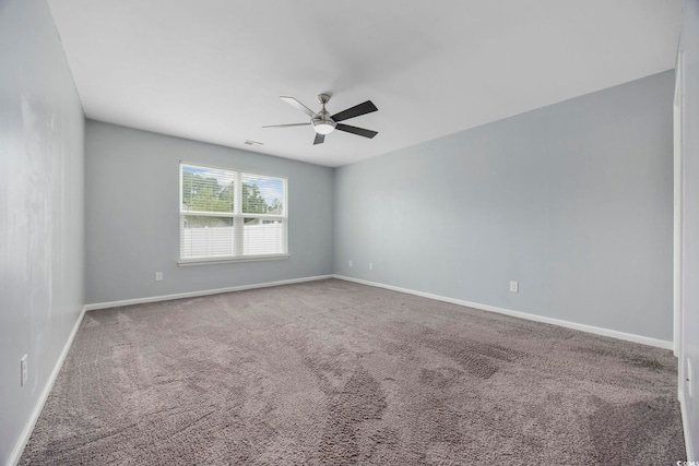 spare room with carpet, visible vents, baseboards, and a ceiling fan