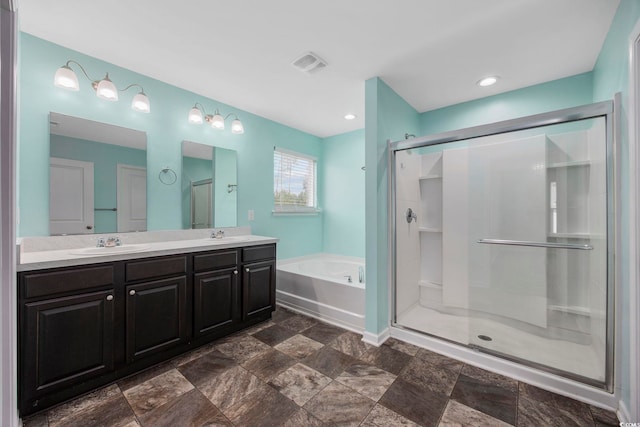 bathroom featuring double vanity, visible vents, a sink, a shower stall, and a bath