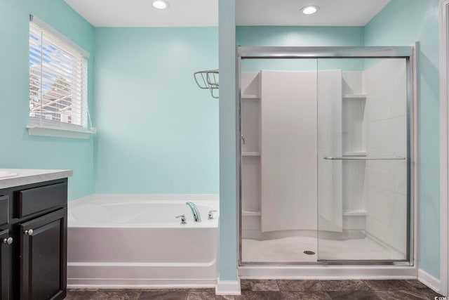 bathroom with a stall shower, recessed lighting, a bath, and vanity