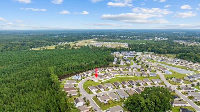 drone / aerial view featuring a wooded view and a residential view