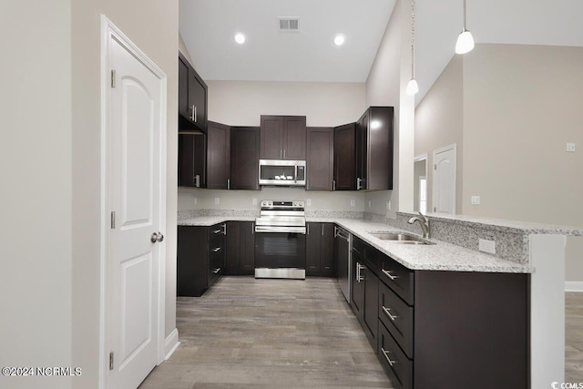 kitchen featuring visible vents, appliances with stainless steel finishes, a sink, dark brown cabinetry, and light wood-type flooring