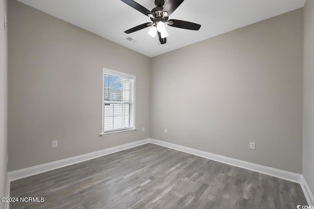 empty room with visible vents, baseboards, ceiling fan, and wood finished floors