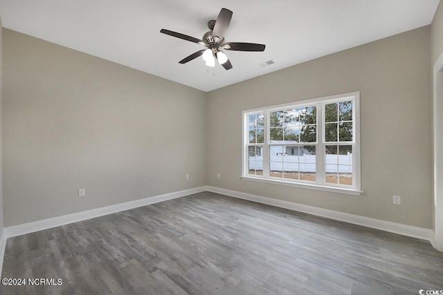 empty room featuring baseboards, visible vents, ceiling fan, and wood finished floors