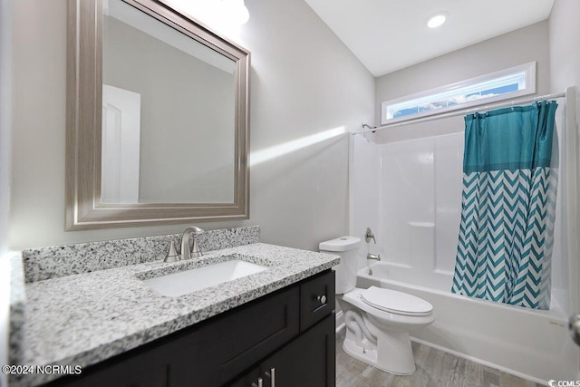 full bathroom featuring toilet, shower / bath combo, wood finished floors, and vanity