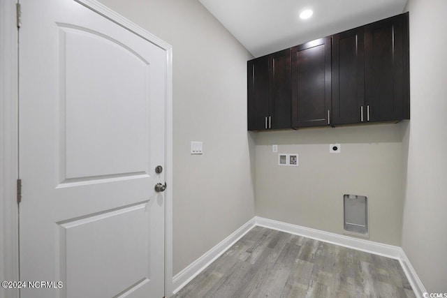 washroom featuring hookup for a washing machine, cabinet space, light wood-style floors, hookup for an electric dryer, and baseboards