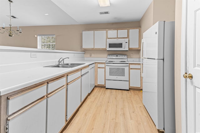 kitchen featuring light countertops, a sink, light wood-type flooring, white appliances, and visible vents