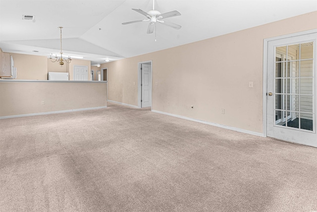 unfurnished living room featuring visible vents, baseboards, ceiling fan with notable chandelier, vaulted ceiling, and light colored carpet