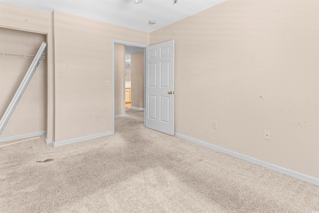 unfurnished bedroom featuring carpet floors, baseboards, and a closet
