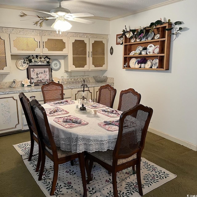 dining space featuring ornamental molding, dark colored carpet, ceiling fan, and baseboards