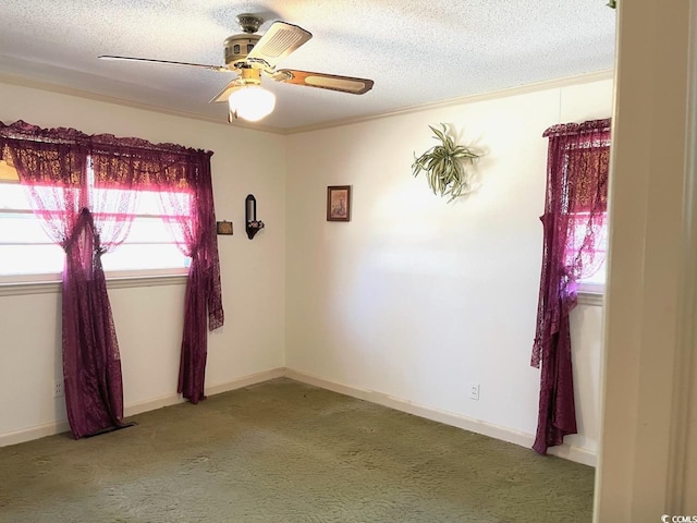 carpeted spare room featuring a textured ceiling, a ceiling fan, and baseboards