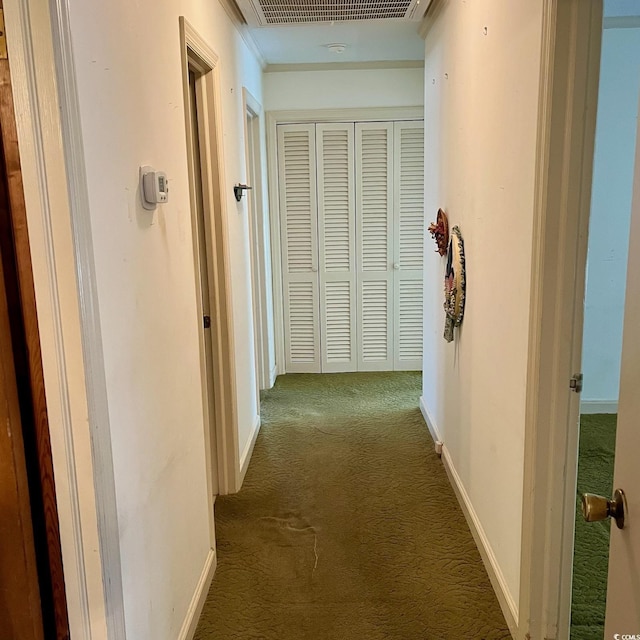 hallway featuring carpet flooring, visible vents, and baseboards