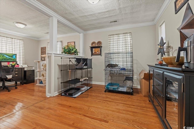 interior space featuring light wood finished floors, visible vents, ornamental molding, a textured ceiling, and baseboards