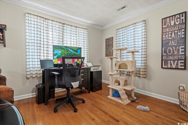 office area featuring a textured ceiling, visible vents, wood finished floors, and ornamental molding