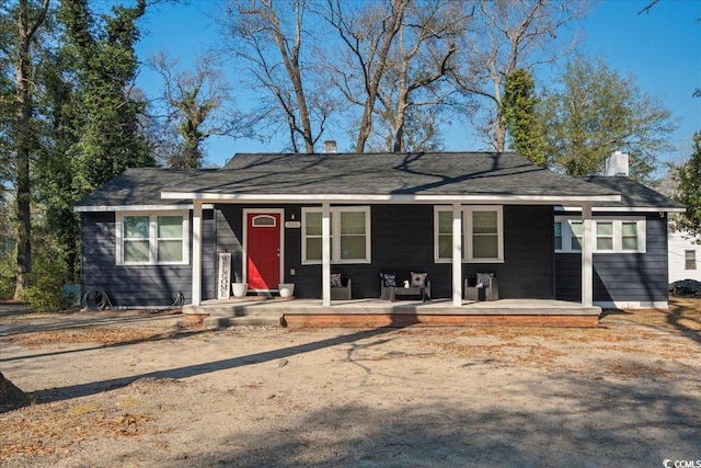 ranch-style house featuring covered porch and a chimney