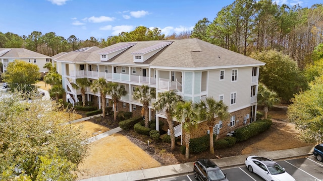 6253 Catalina Dr Unit 921, North Myrtle Beach, SC 29582 - view of building exterior with uncovered parking and view of wooded area