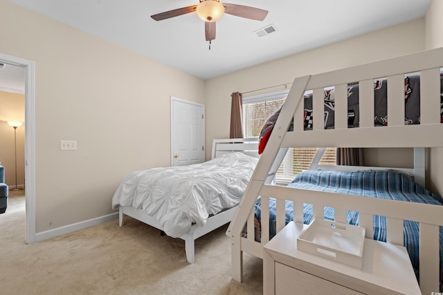 bedroom with light carpet, ceiling fan, visible vents, and baseboards